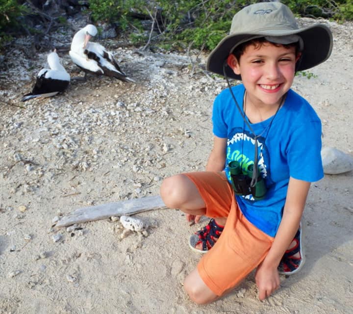 Boy posing with endemic Nazca Boobies in the Galapagos