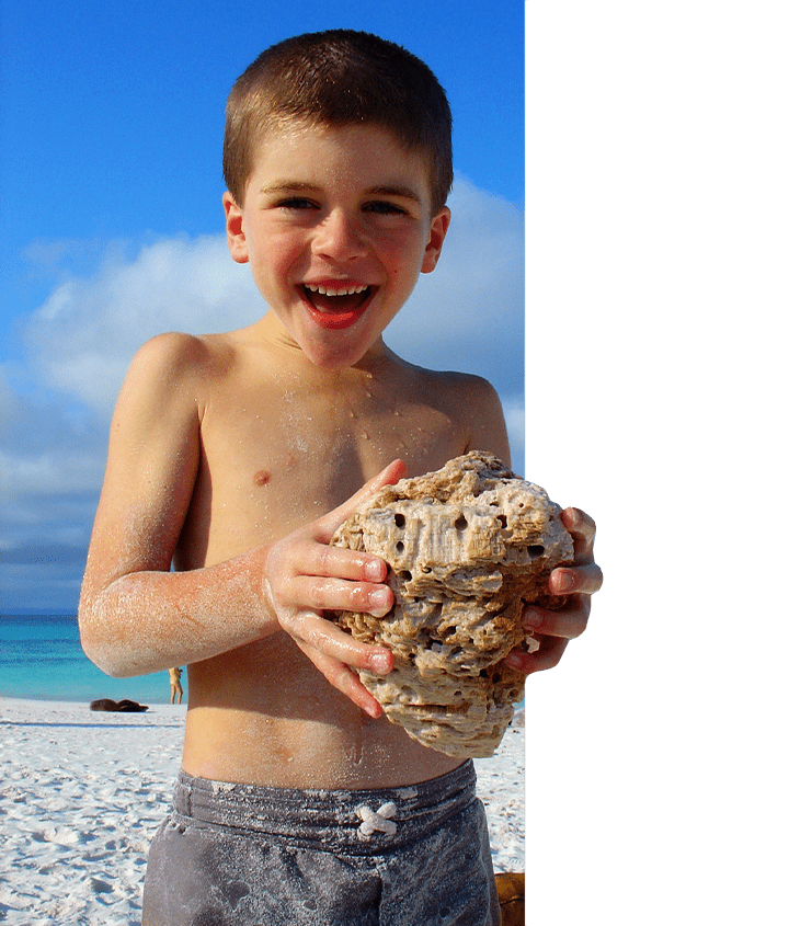 Boy holding seashell on a Galapagos Family Trip