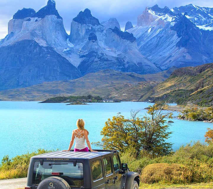Traveler sitting atop a Quasar Jeep looking out to Torres del Paine National Park
