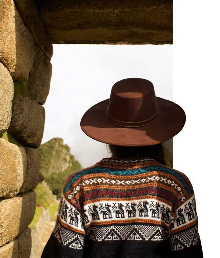 A woman walking thru one of the structures of Machu Picchu