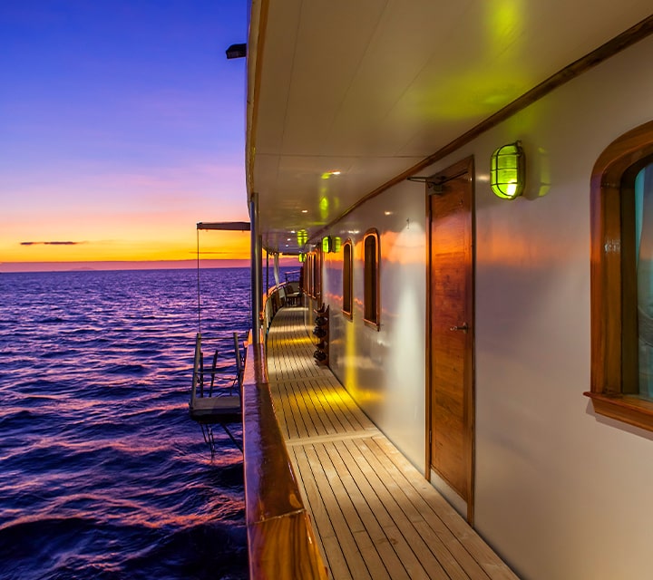 Spacious exterior of Grace Yacht from the side at the golden hour in the Galapagos Islands