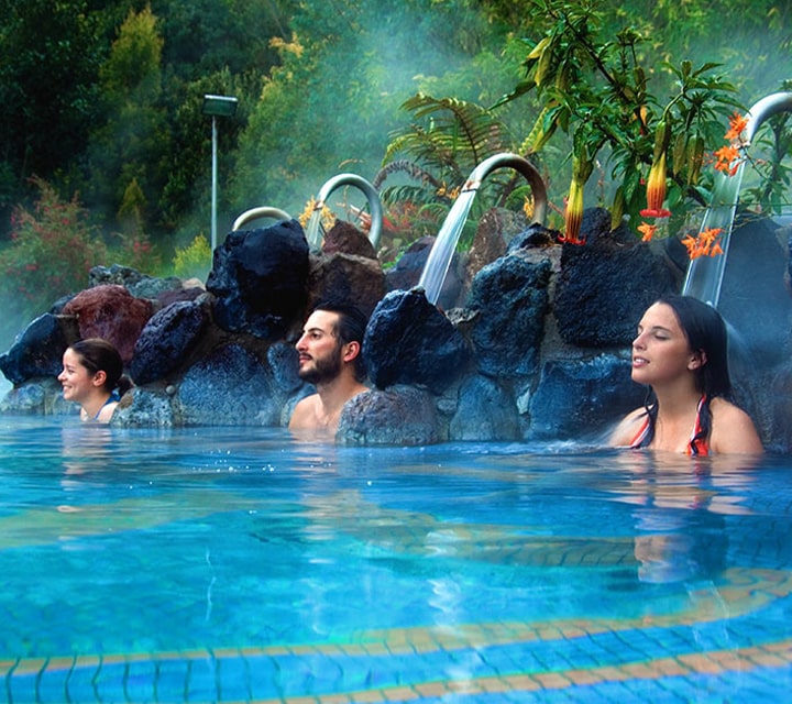Two women and a man enjoying a soak in the thermal pools of Ecuador's Papallacta Hot Springs and Spa