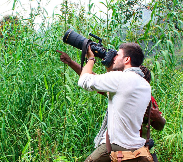 Professional photographer, Harry Skeggs, holding a Nikon camera to capture photos of wildlife