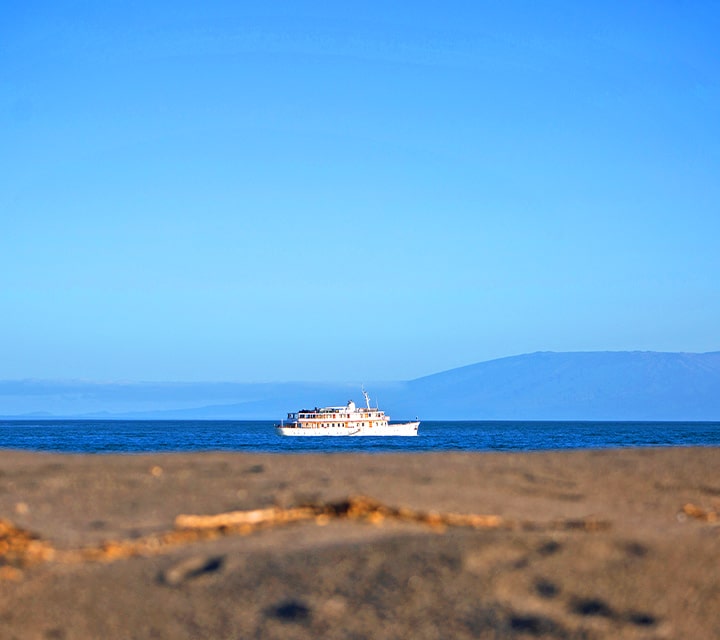 Clear blue skies, view of Grace yacht from land on Galapagos Islands