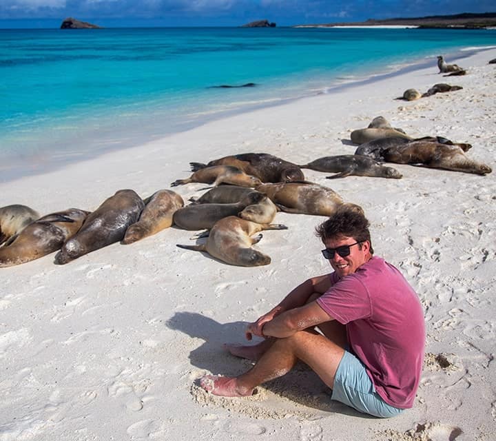 Man on beach with Galapagos Sea Lion